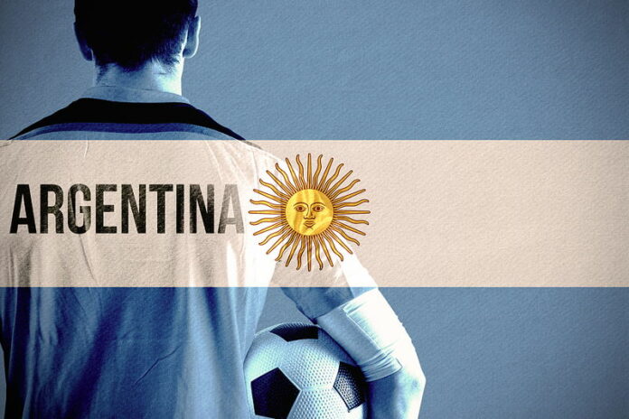 footballer holding ball argentina flag