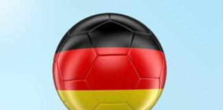 football painted with germany flag close up on grass sky background