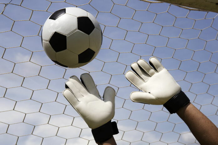 goalkeeper trying to make a save ball just out of reach going into the top corner of the goal