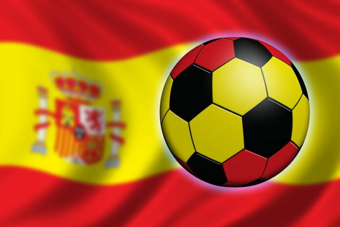 football painted with spain flag with blurred spain flag background