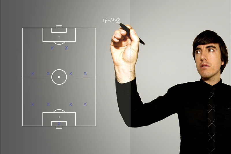 football manager writes up a 4-4-2 formation on a glass pane