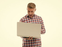 casual man playing football manager on a laptop