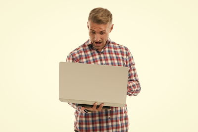 casual man playing football manager on a laptop